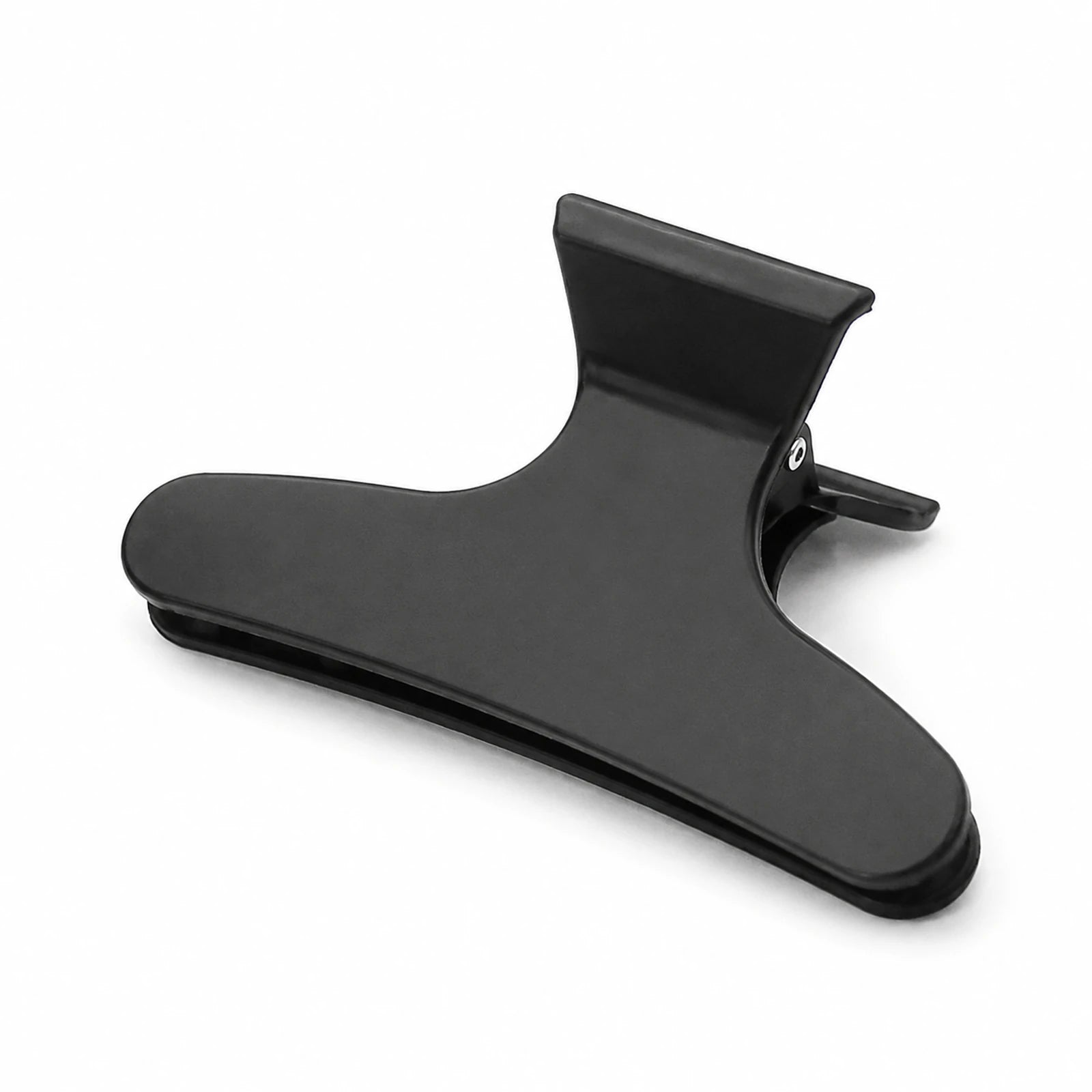 MUSEVA black curved hair clip form with broad body and paired jaws on warm ivory.
