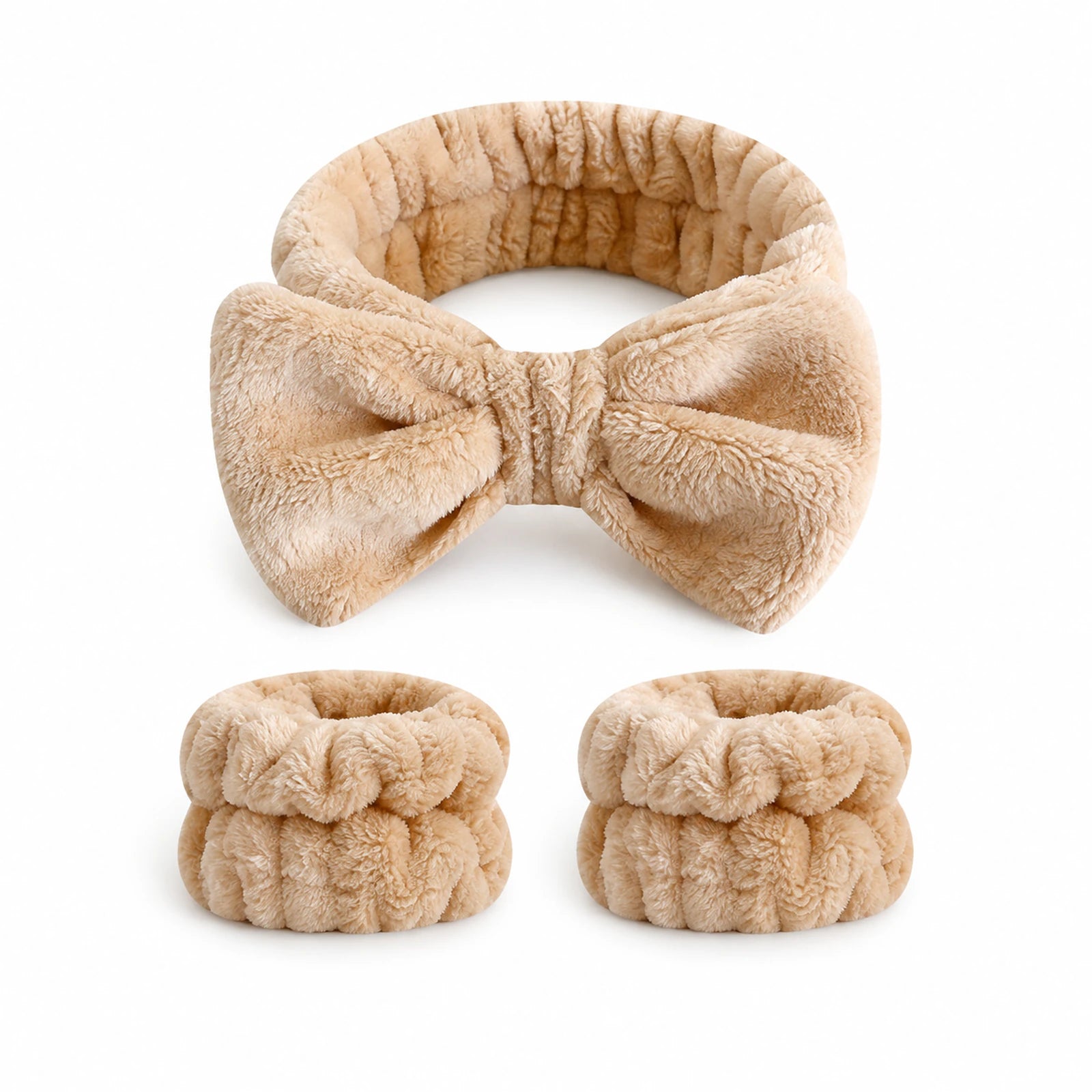 MUSEVA bow-front spa headband and two matching wristbands on warm ivory.